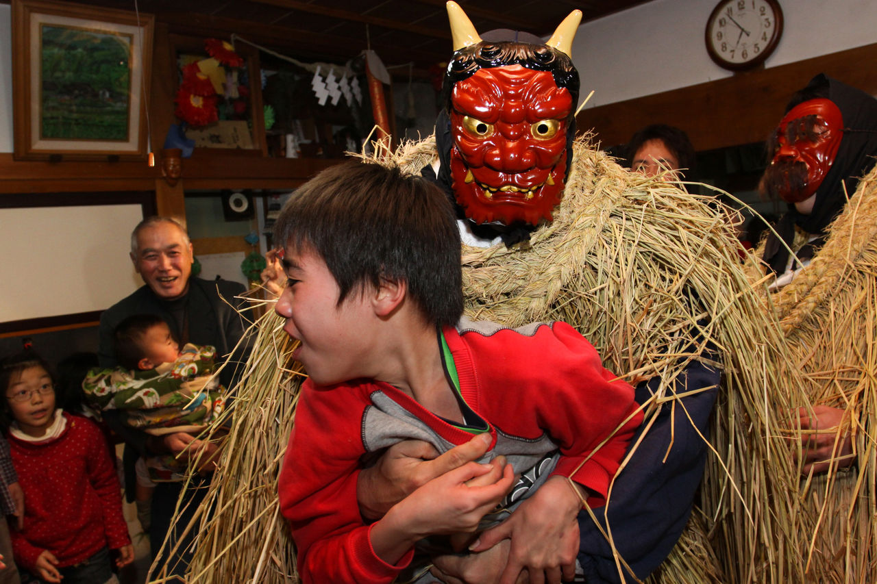 An <em>amahage</em> wearing a fierce mask exhorts a child to be good or else. (Courtesy Yuza Board of Education)