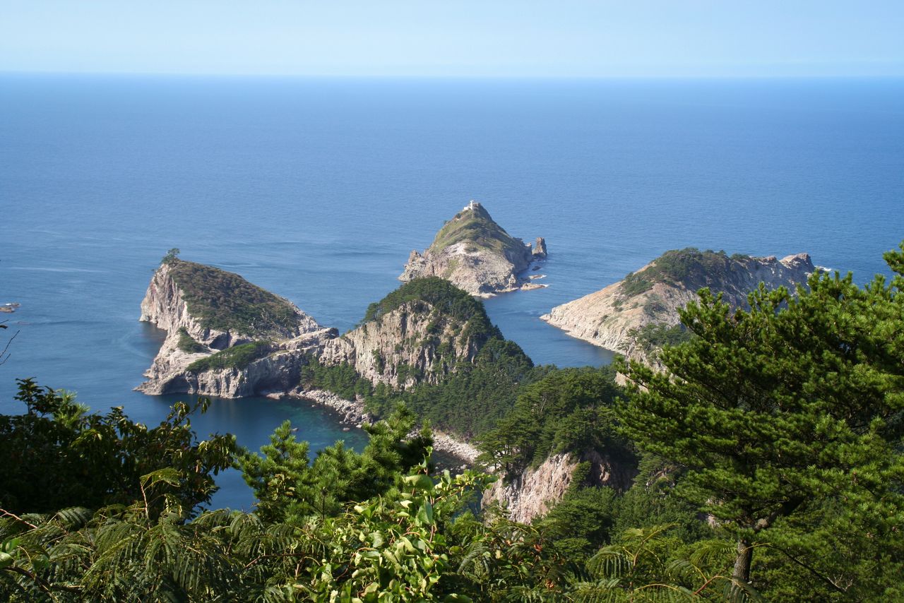 The Shirashima coast, at the northern tip of Dōgo, is a designated scenic area and a natural monument. A panorama of rough-hewn islets and green pines unfolds against the blue waters of the Sea of Japan. (Courtesy Okinoshima Town Office)