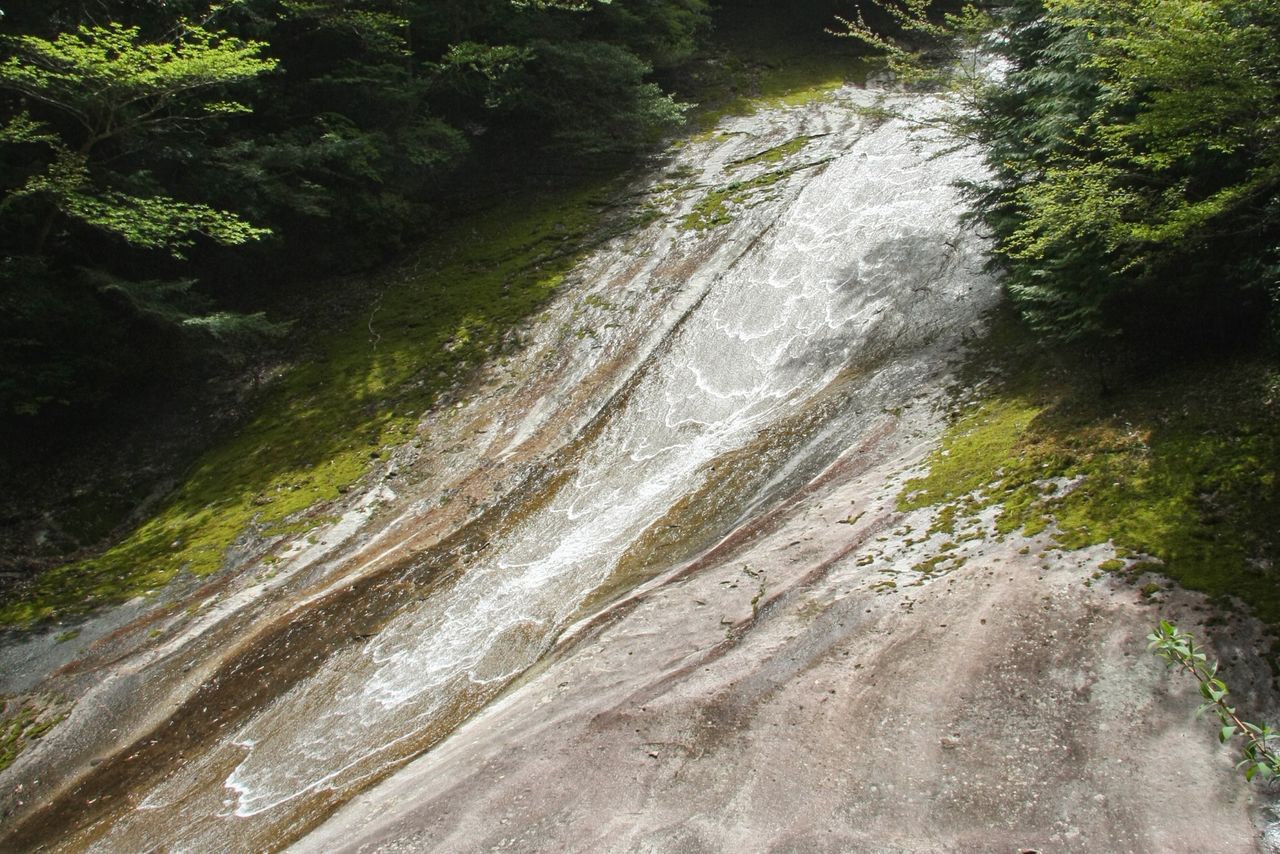 Yukiwa Falls, 20 meters wide and 300 meters long, flows down the smooth rock slabs of Nametoko Gorge. A 12-kilometer-long walking trail runs along the gorge. (Courtesy Ehime Local Promotion Association)