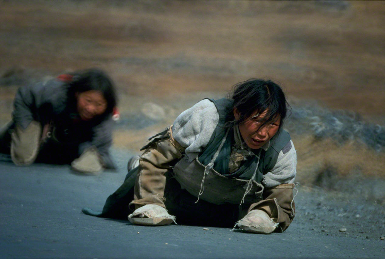 Prostrate pilgrims crawl toward Lhasa, reciting texts from Buddhist sutras. Photographed in 1989. (From Tibet)