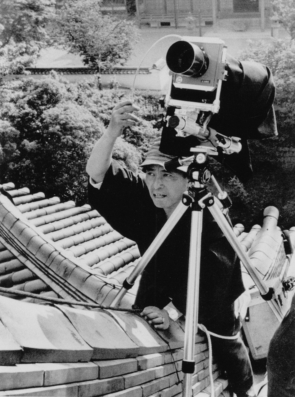 Domon Ken in 1964, shooting the phoenix statues on the roof of the Phoenix Hall at Byōdōin in Uji, outside Kyoto. (Collection of the Domon Ken Museum of Photography)