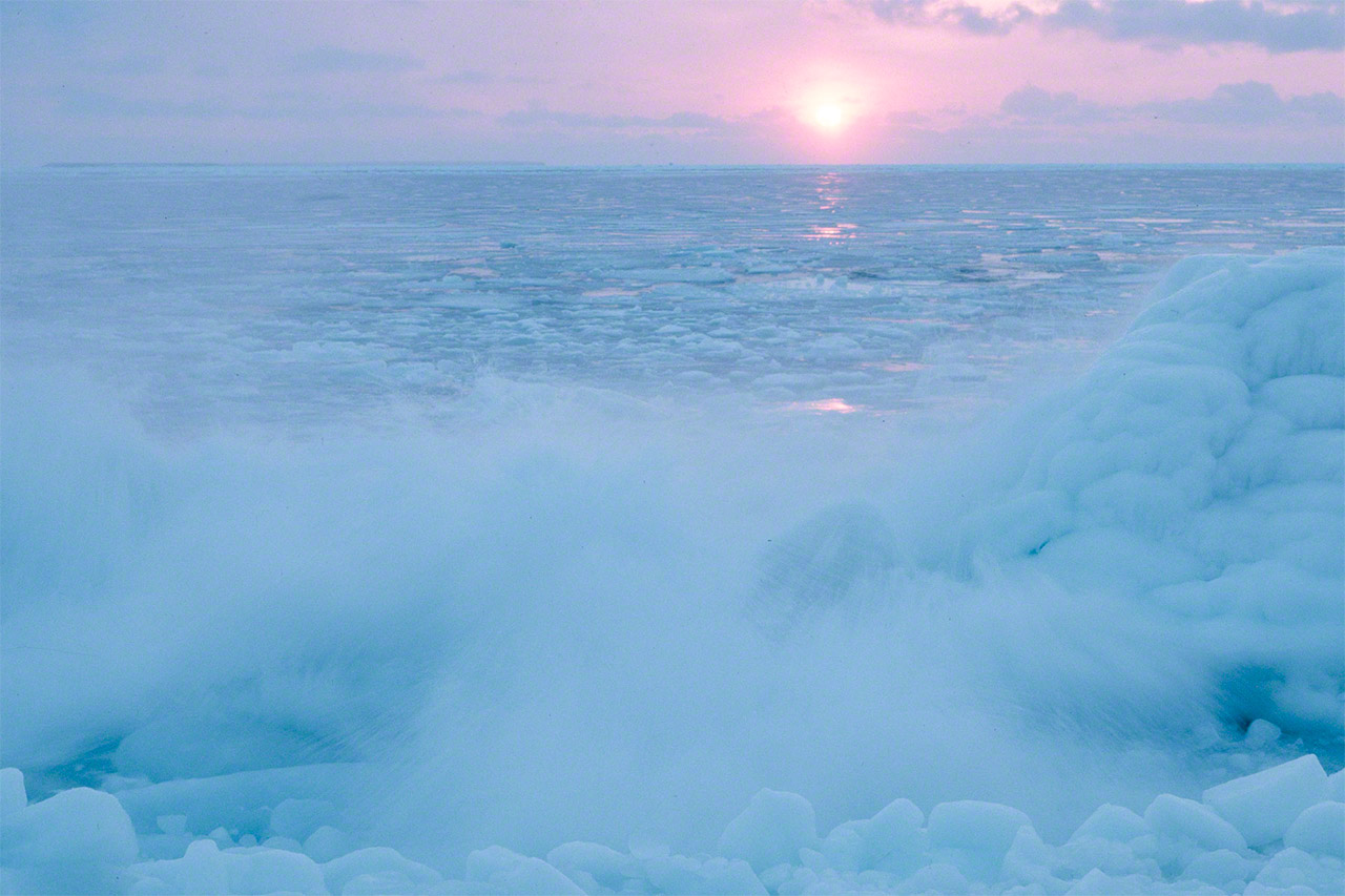 The sun rising above drift ice that has moved around the Nemuro Peninsula to head south in the Pacific Ocean. (© Mizukoshi Takeshi)