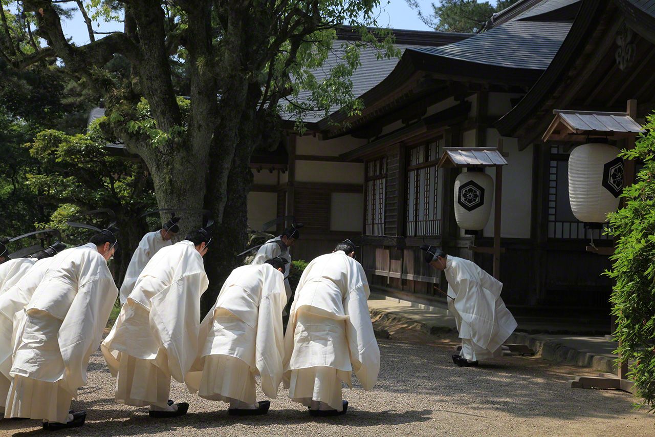 Priests bow in greeting before a shrine ceremony.