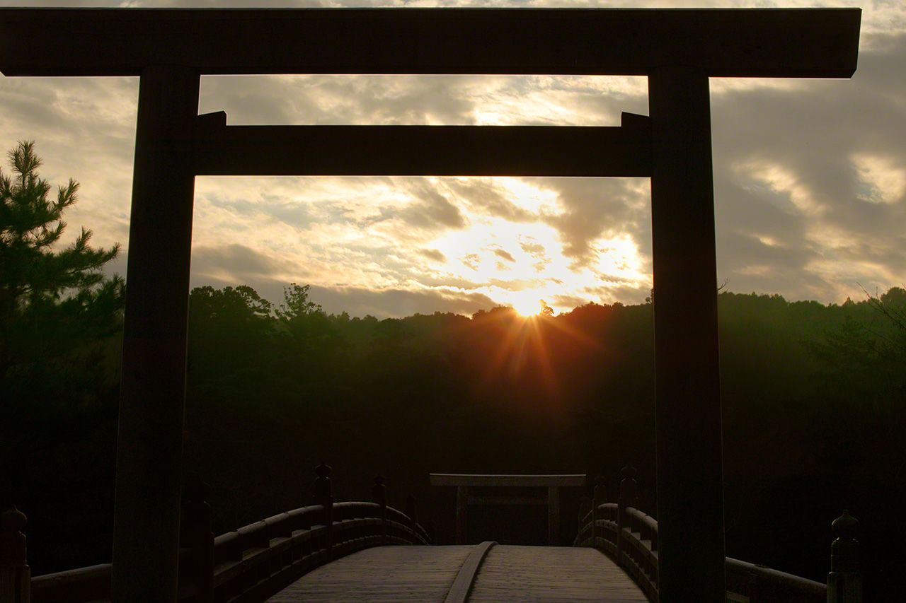 January 1 The first sunrise of the New Year. Crowds of worshipers join their hands in prayer as the sun rises over the Uji Bridge.