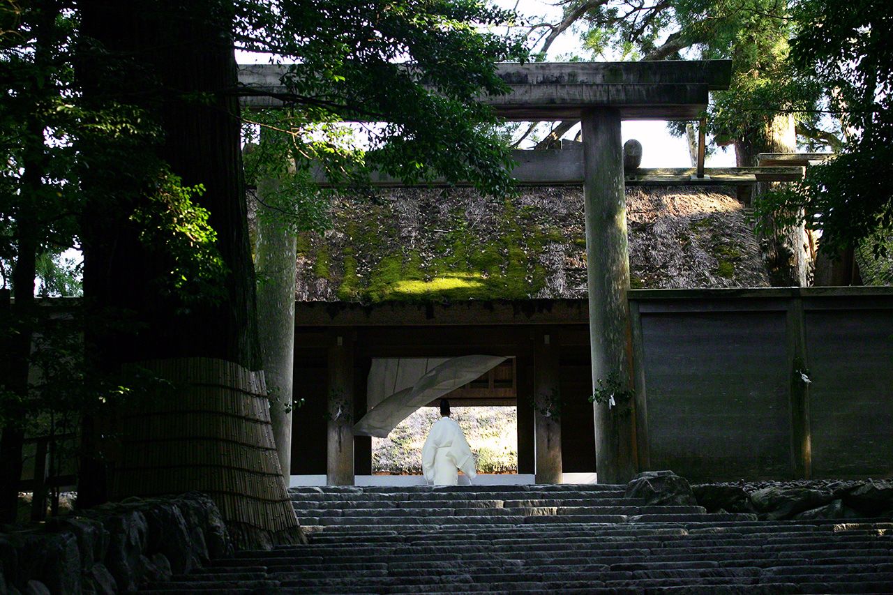 July 1<br>A curtain hung across the shrine entrance is blown back by a gust of wind as a priest approaches.