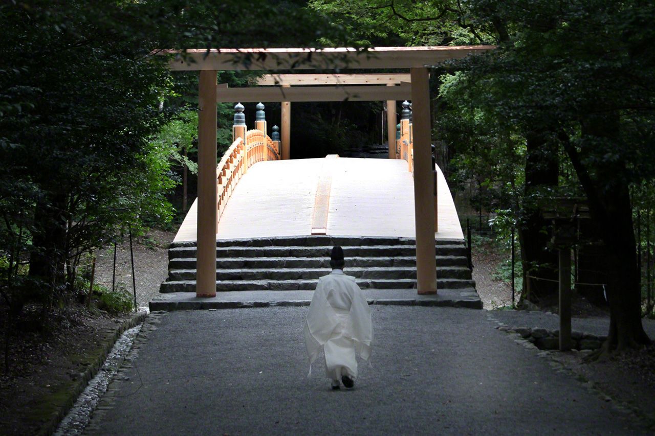 August 25 A priest makes his way toward the newly rebuilt Kazahi-no-minomiya Bridge.