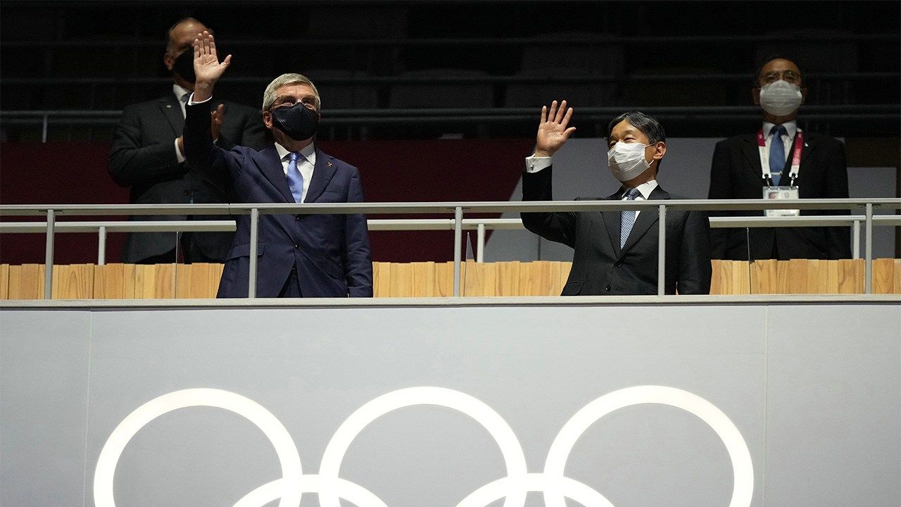 Emperor Naruhito, at right, waving at the opening ceremony of the Olympic Games alongside Thomas Bach, president of the International Olympic Committee, on July 23, 2021. (© Jiji)