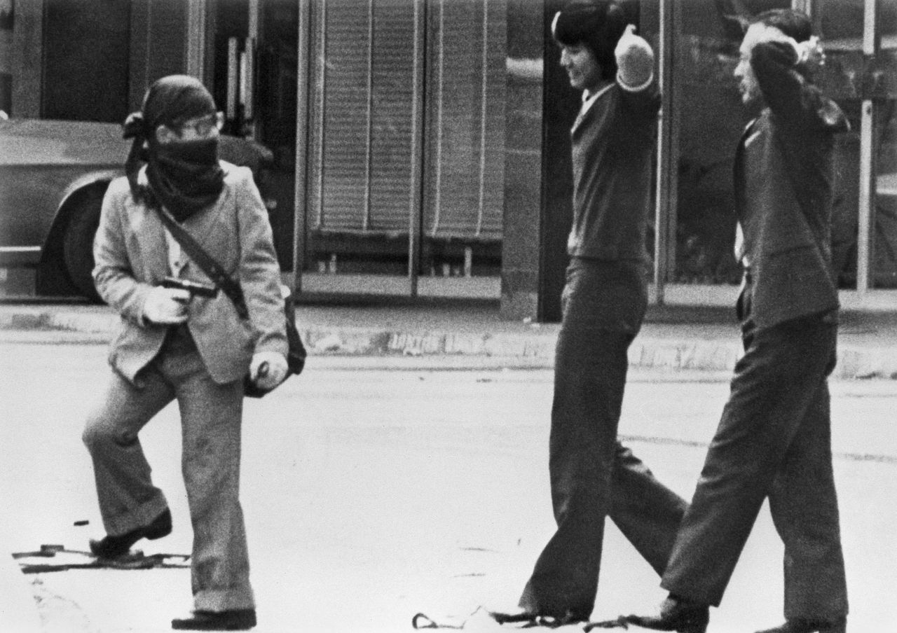  A Japanese Red Army member with a gun and two hostages on August 7, 1975. Five members of the group assaulted the US and Swedish embassies in Kuala Lumpur, demanding the release of imprisoned radicals in Japan. They escaped to Libya after the incident. (© Jiji)