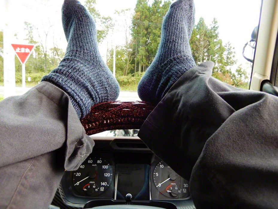 While often slammed as bad etiquette, the practice resting one’s feet on the steering wheel during breaks is a way to relieve the fatigue of hours of driving. (© Hashimoto Aiki)