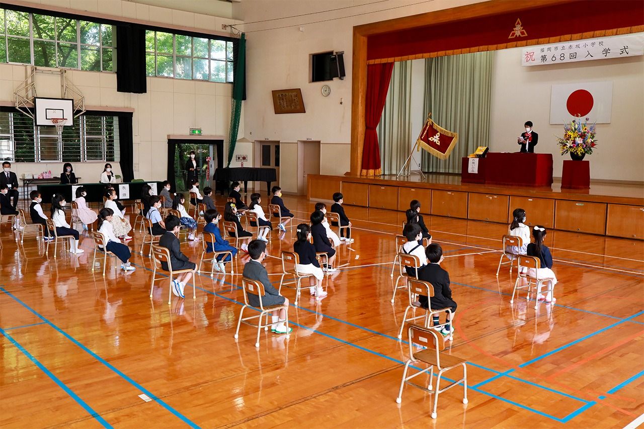 An elementary school in the city of Fukuoka holds its entrance ceremony on June 23 after the national state of emergency is lifted. The ceremony is held at different times for each of three classes. All the first graders wear masks while the sixth graders who usually welcome them are not in attendance. (© Jiji)