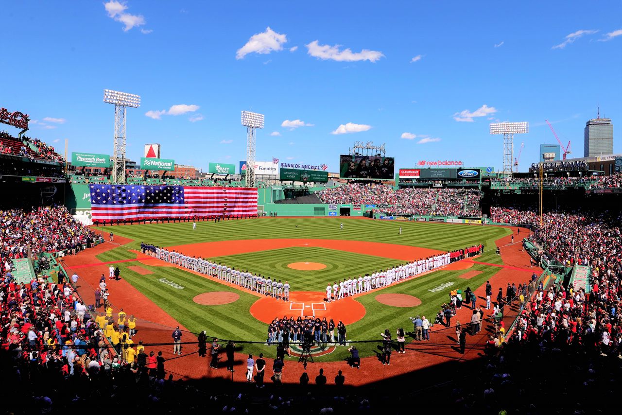 Fenway Park, known for its symmetrical design. When it was first built, left field had a shorter distance from home plate, and so an enormous fence was constructed to reduce the number of home runs. Nicknamed the “Green Monster,” the fence is still known by that moniker. On Jackie Robinson Day, April 15, 2022, an enormous American flag was draped over the fence. (© AFP/Jiji)
