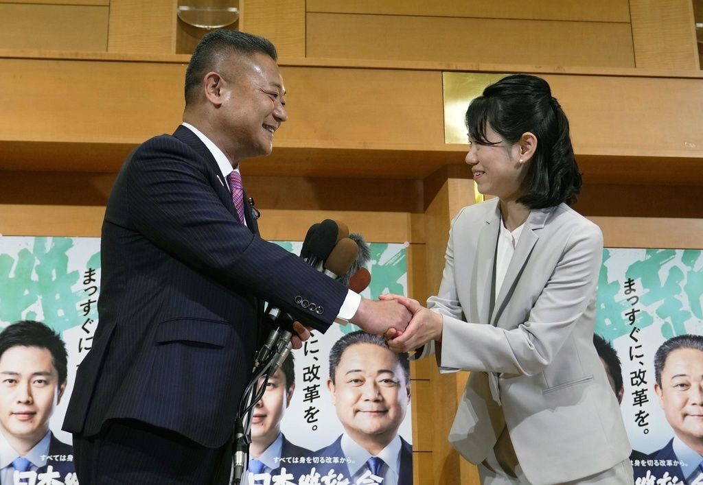 Hayashi Yumi shaking hands with Ishin no Kai chief Baba Nobuyuki (left) on April 23, 2023, after winning the House of Representatives seat for the Wakayama 1 constituency. (© Kyōdō)