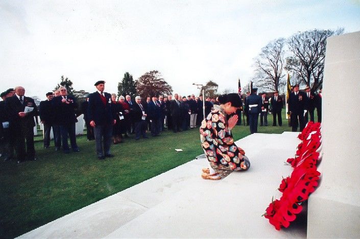 Kosuge Nobuko praying at a memorial ceremony held at a cemetery in Cambridge on Remembrance Day. This photo appeared on the front page of the Cambridge Evening News, a local newspaper, in November 1996. (Courtesy of Kosuge Nobuko).