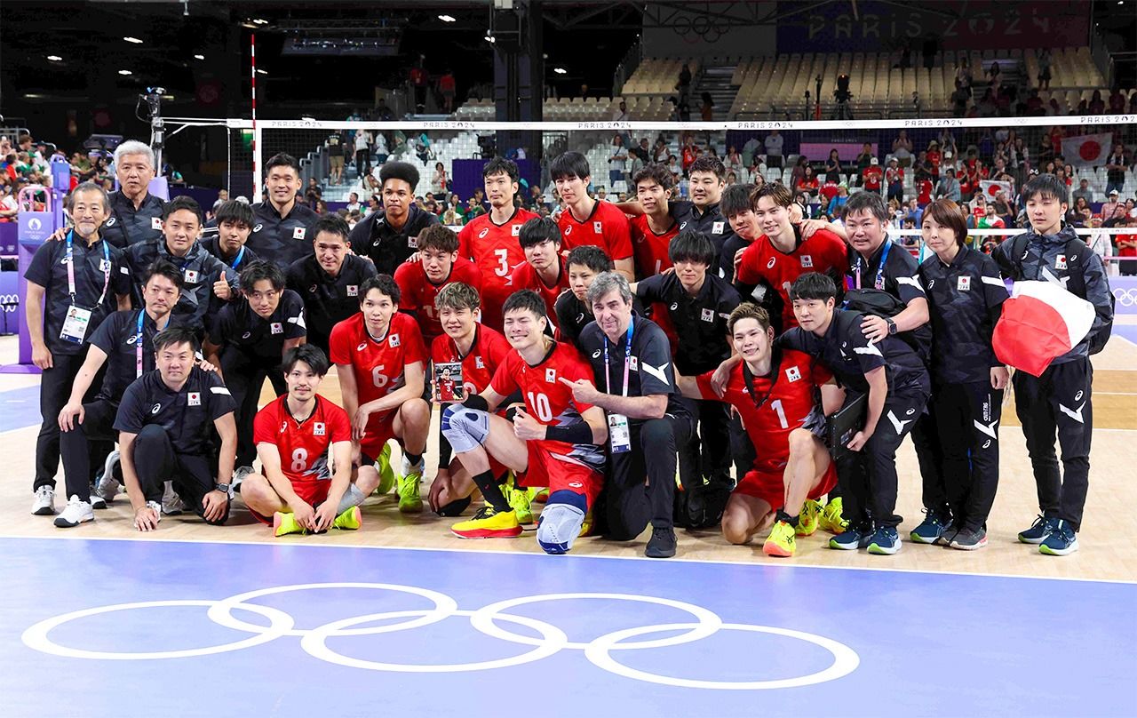 Japan’s men’s volleyball team and staff pose for a commemorative photo following the quarterfinal match. (© Jiji)