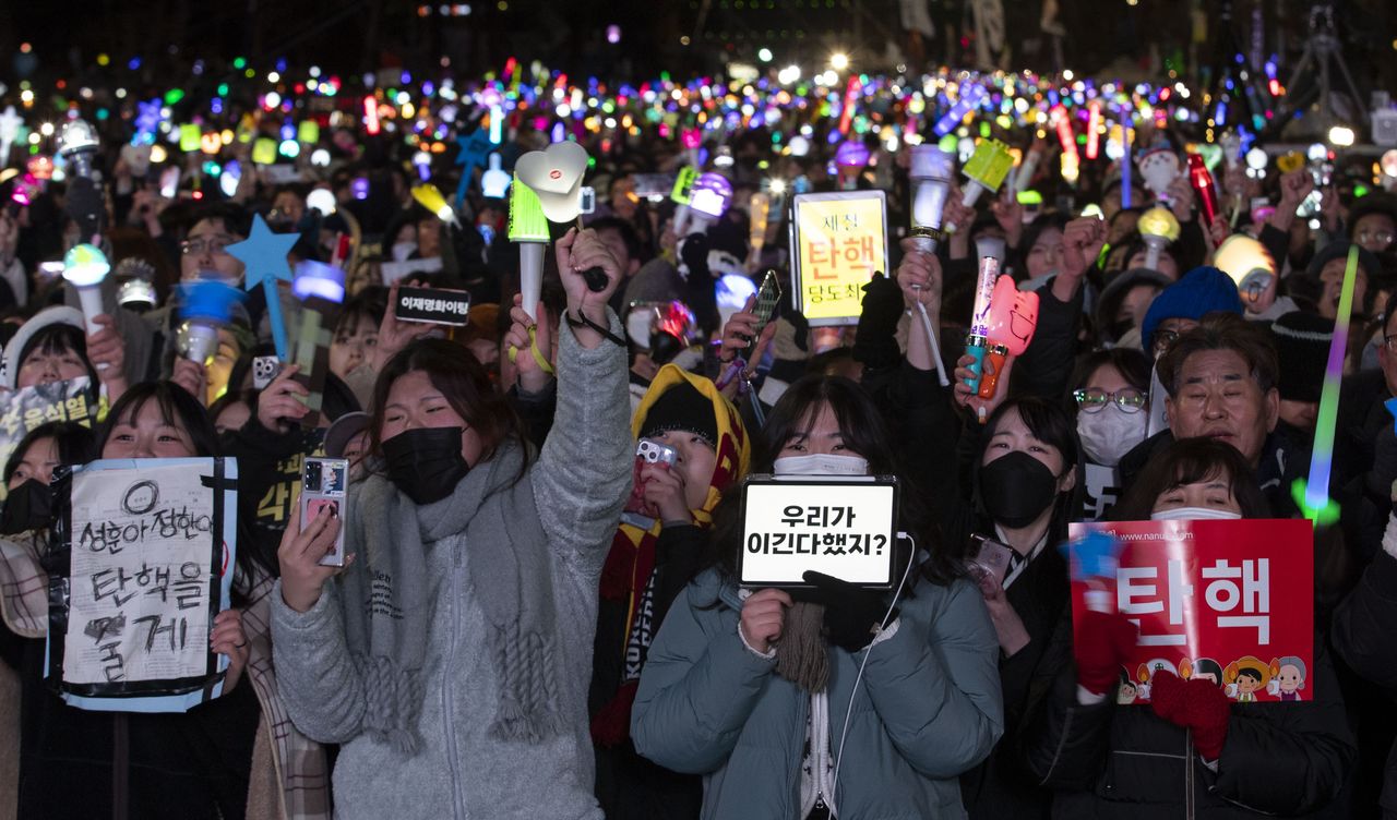 Demonstrators in front of the National Assembly in Seoul celebrate passage of the motion to impeach President Yoon on December 14, 2024. © Lee Young Ho/Sipa USA; via Reuters Connect)