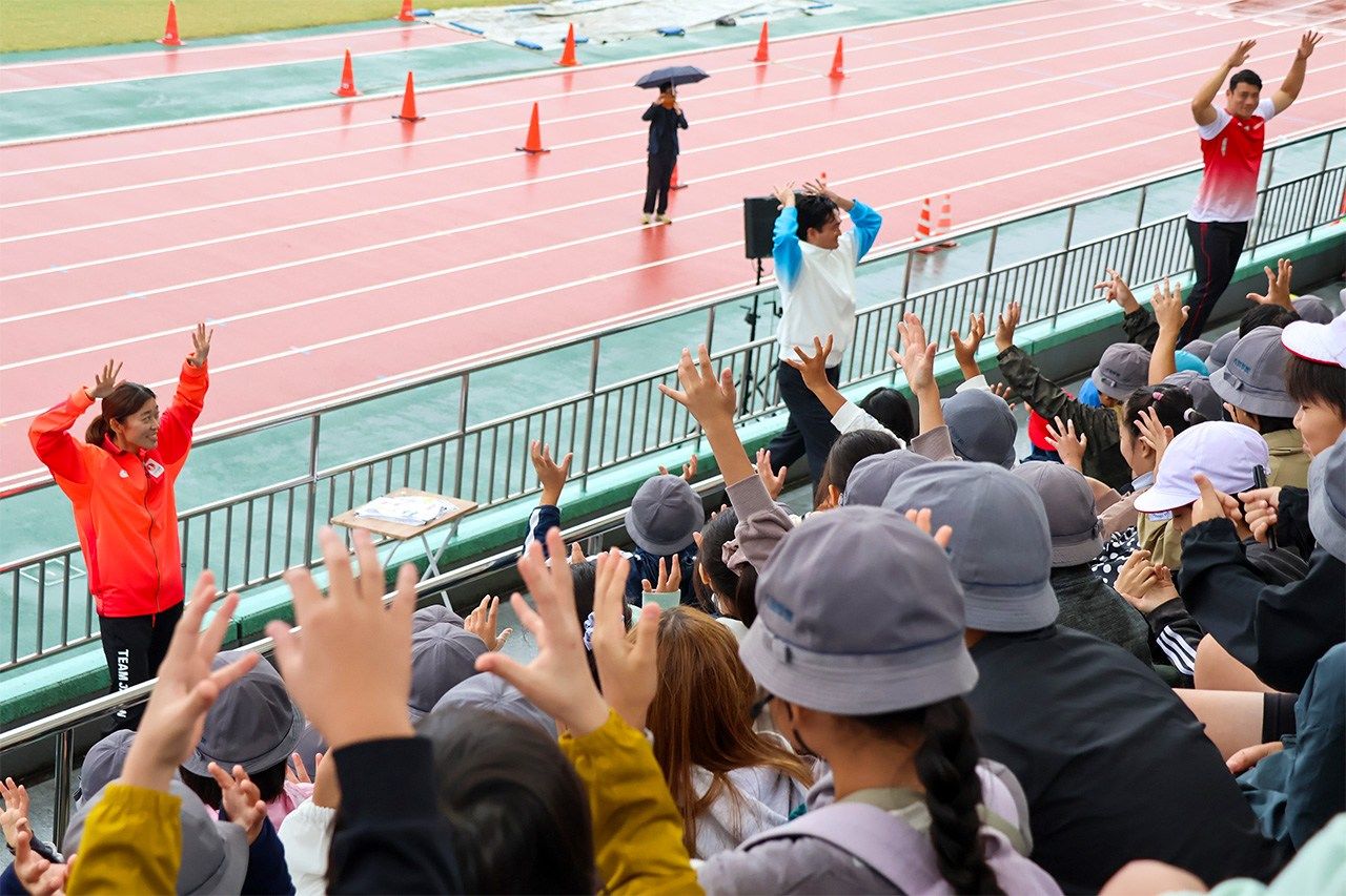 Schoolchildren practice “cheer signs” at a Deaflympics promotional event a month before the games. (© Matsumoto Sōichi, Nippon.com)