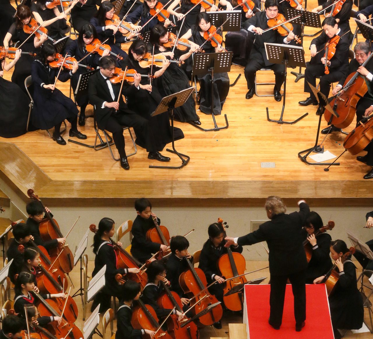 Crown Prince Naruhito (second from right on stage) and Princess Aiko (fourth from the stage at bottom left) perform together at a Gakushūin concert in April 2013. (© Jiji; pool photo)