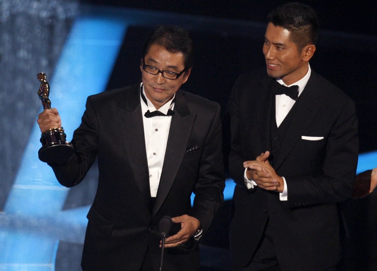Departures director Takita Yōjirō (left) holds his film’s Oscar statuette, standing alongside star Motoki Masahiro, on February 22, 2009. (© Reuters)