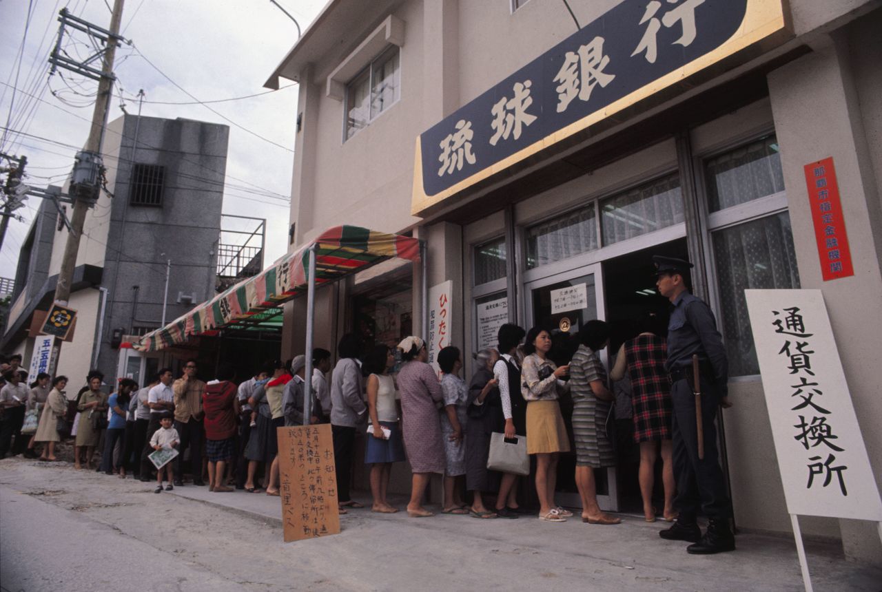 Citizens in Naha line up to change their dollars for yen ahead of Okinawa’s reversion. (© Jiji)