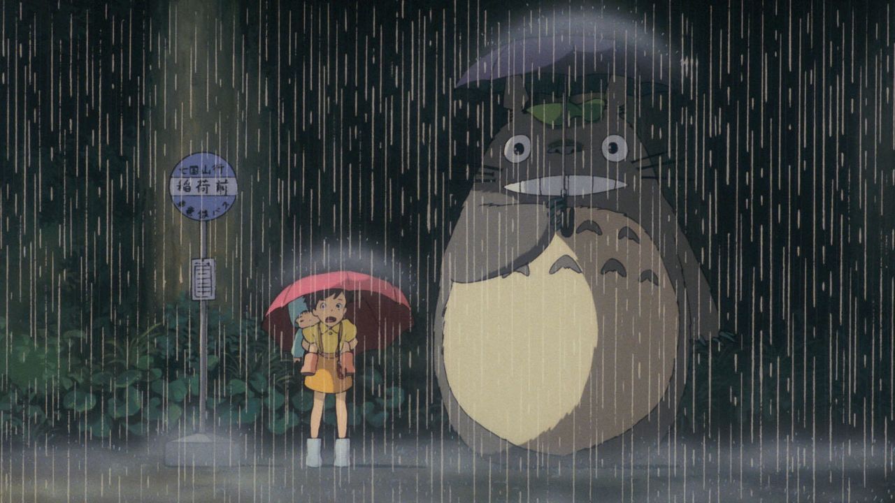 The girls and Totoro wait for the bus in My Neighbor Totoro. (© Studio Ghibli)