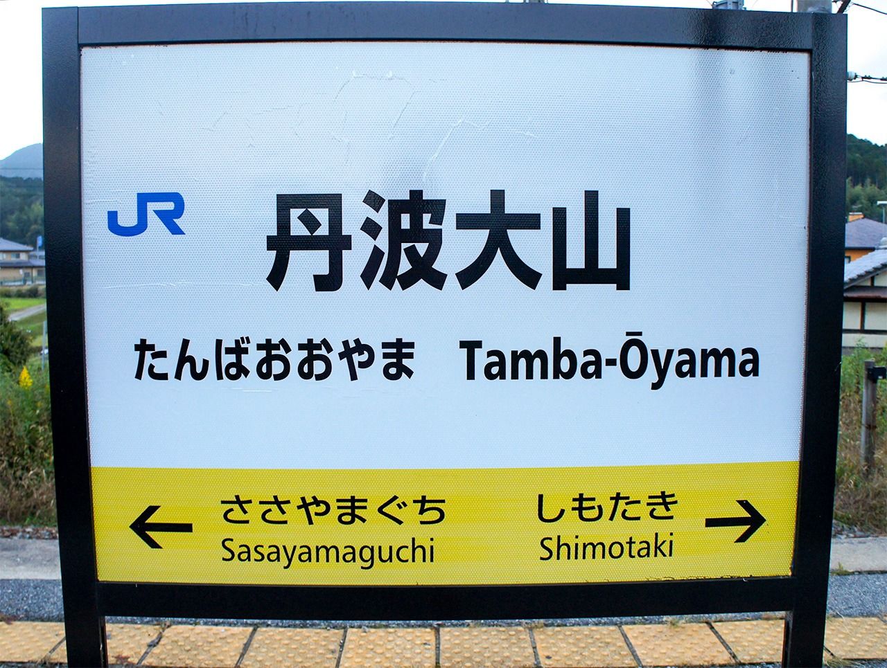 A train station sign displaying “Tamba” in Hepburn spelling. (© Pixta)
