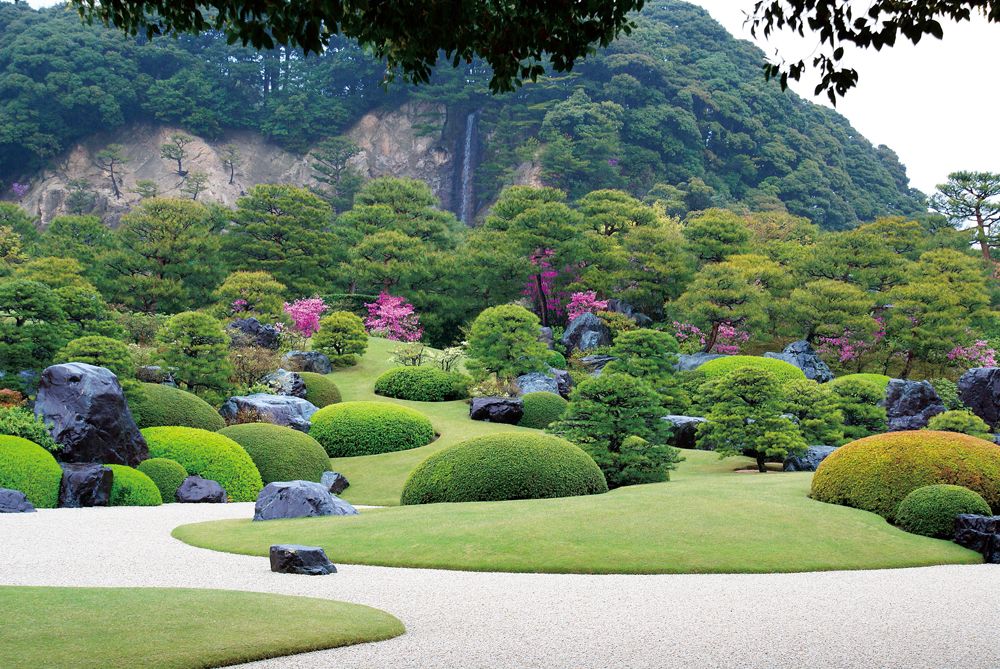 Mount Kikaku forms the backdrop to the karesansui (dry landscape) garden at Adachi Museum of Art, from which the artificially created Kikaku Waterfall drops fifteen meters, representing the scenery found in Yokoyama Taikan’s work Waterfall in Nachi. (© Adachi Museum of Art. Reproduction/copying of the image prohibited.)