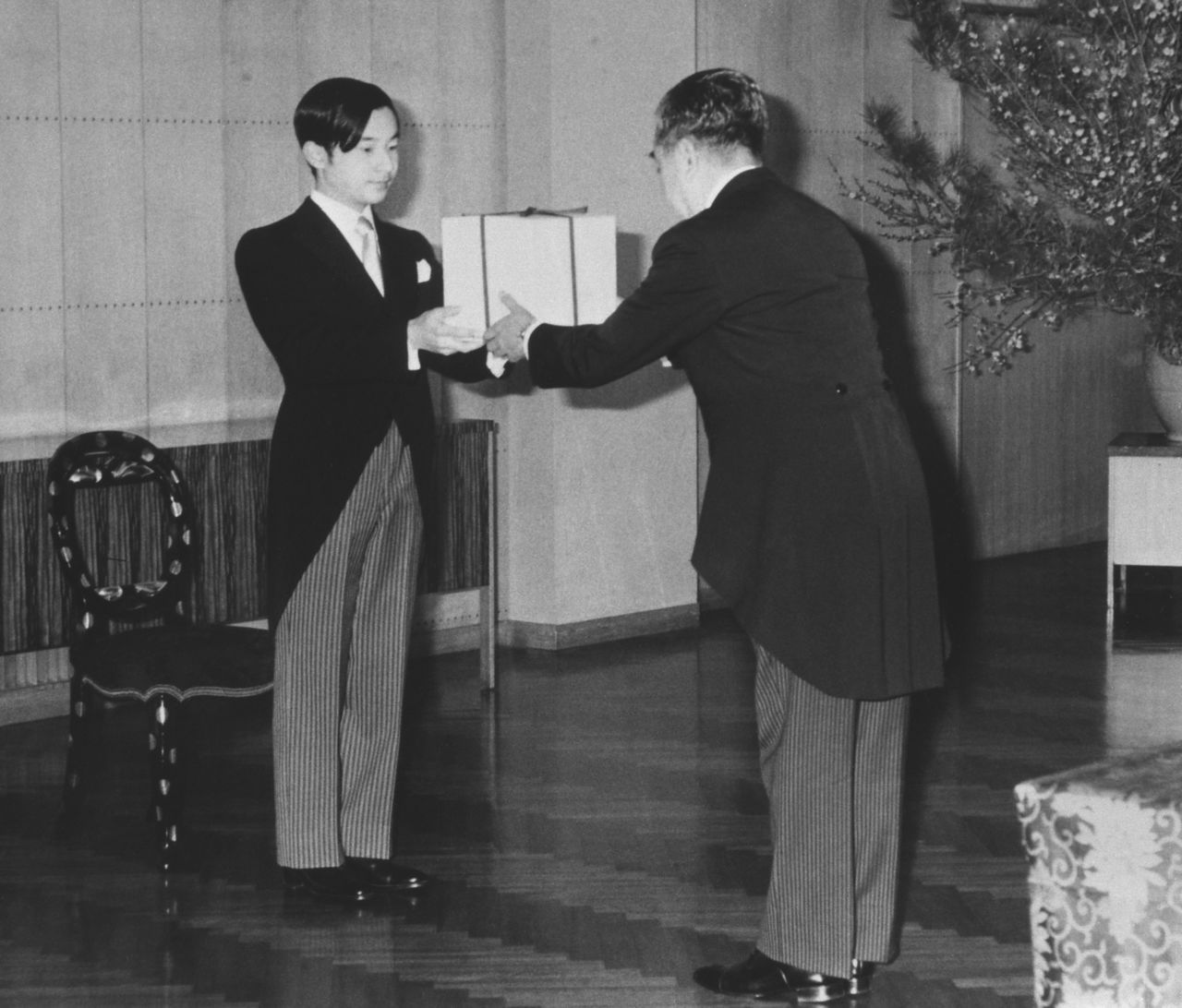 In a February 23, 1980, ceremony, Prince Naruhito receives the kanmuri headpiece. (© Jiji; pool photo)