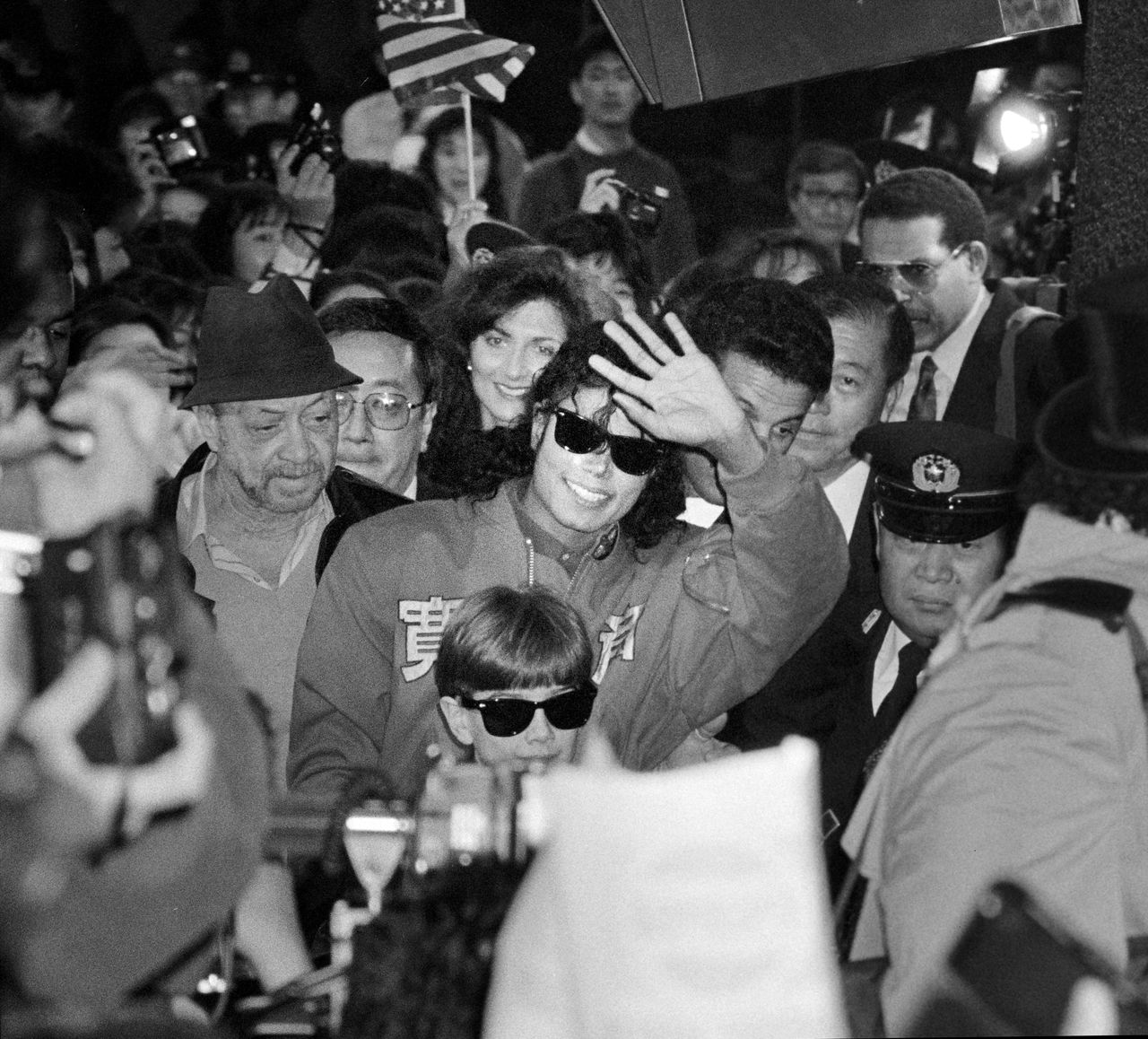 Michael Jackson, at the start of his Japan tour, waving to cheering fans gathered to greet him in the arrival lobby of Narita Airport on December 8, 1988. (© Jiji)