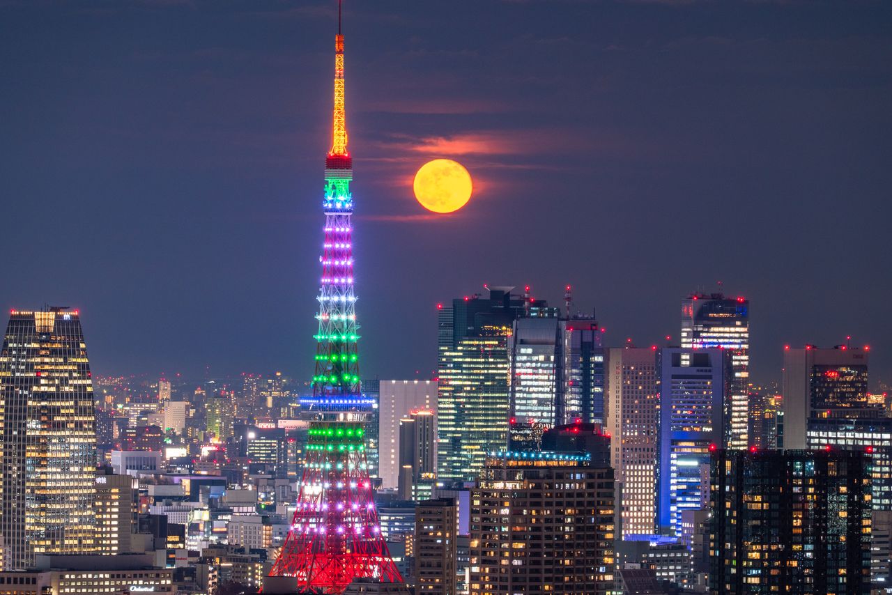 Tokyo Tower and the full moon. (© Pixta)