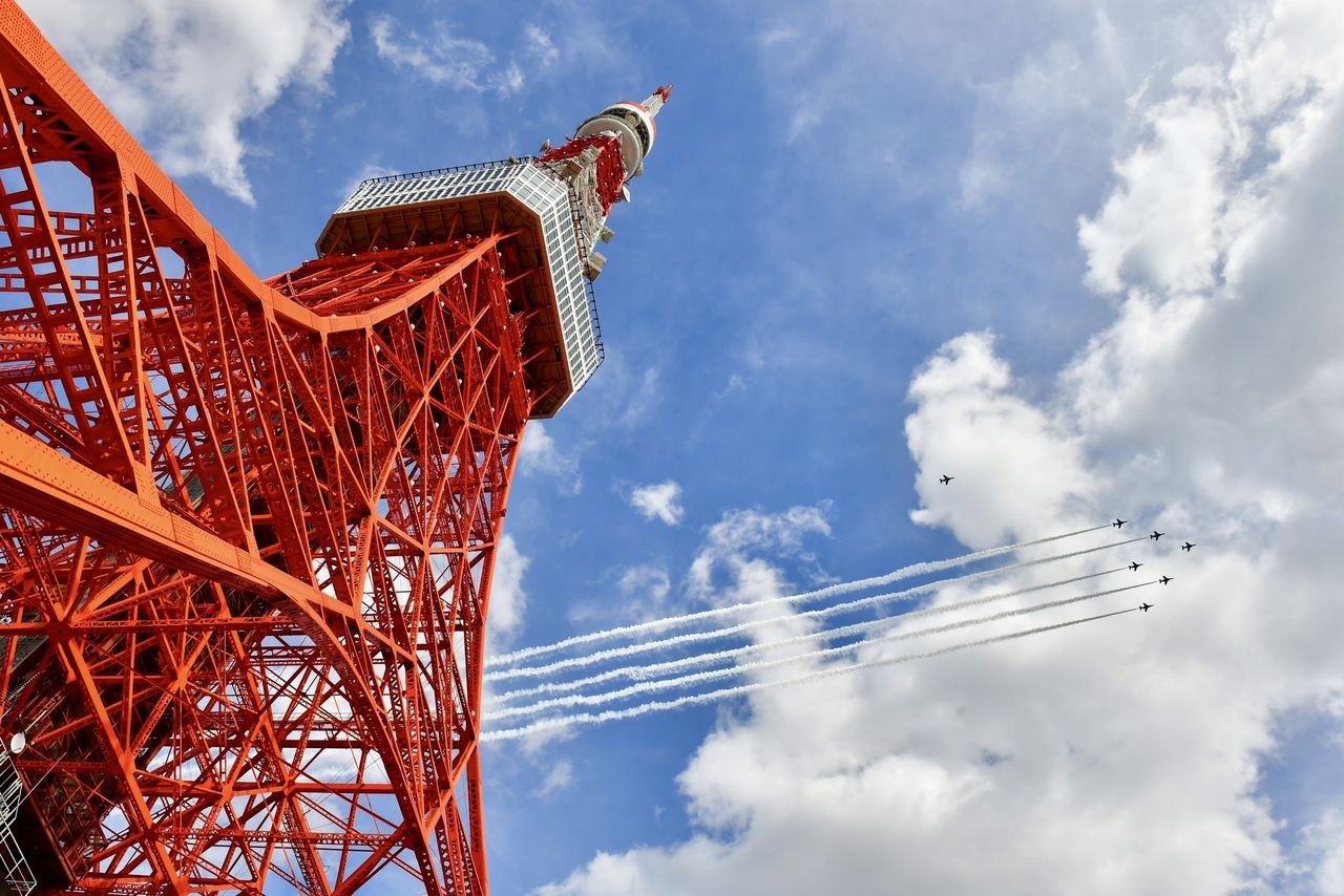 Japan's Air Self-Defense Force Blue Impulse aerobatic team flies above the tower. (© Pixta)