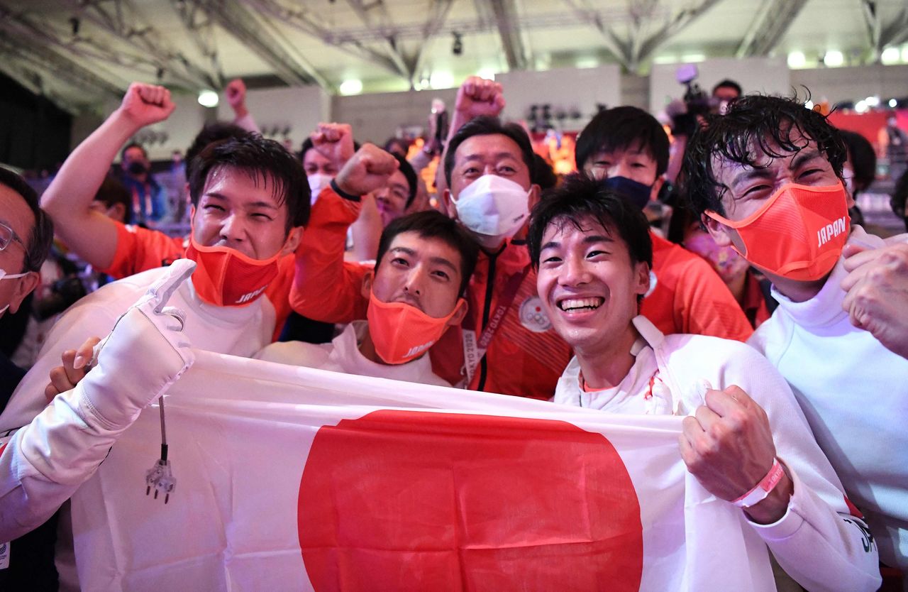 Japan’s Épée Army smiles after winning their battle on July 30, 2021, at Makuhari Messe in Chiba Prefecture. The experienced team has an average age of 28.3 years. (© AFP/Jiji)