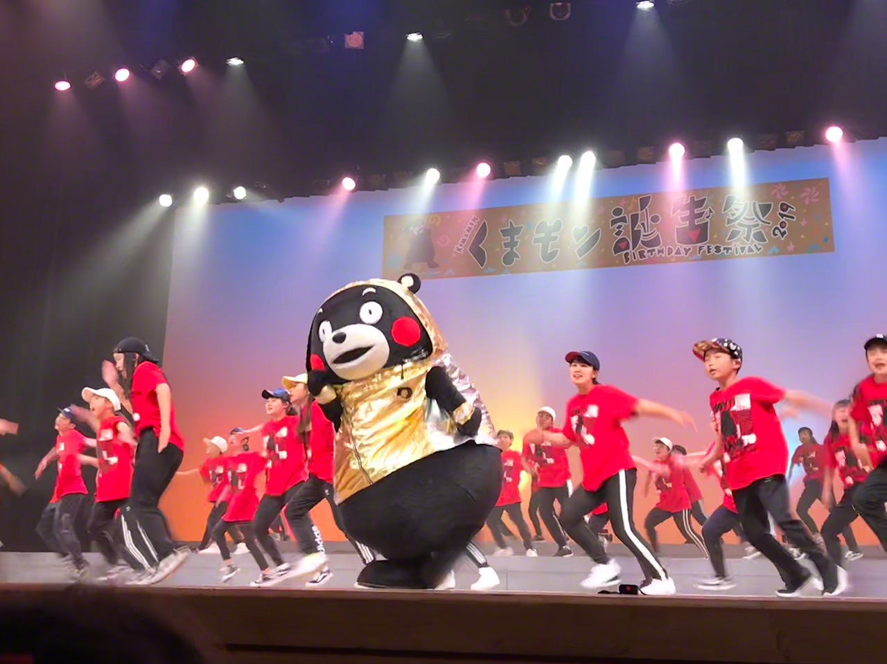 Dancers join Kumamon at a birthday event for the mascot held in March 2019 at the Kumamoto Civic Auditorium. (Courtesy Kumamoto Prefecture)