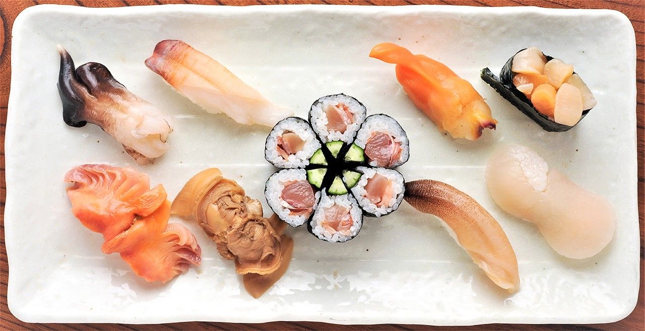 A plate of sushi made from the edible mollusks once plentiful in Tokyo Bay: (center) akagai frill with cucumber; (clockwise from upper left) torigai, honmirugai, aoyagi (bakagai), kobashira (adductor muscles of the aoyagi), tairagi, shiromirugai, hamaguri, and akagai.