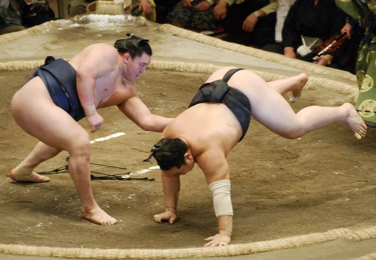 Hakuhō, left, throws Asashōryū in the final bout of the summer tournament on May 27, 2007, to win the title with a perfect 15–0 record and secure promotion to yokozuna. (© Jiji)