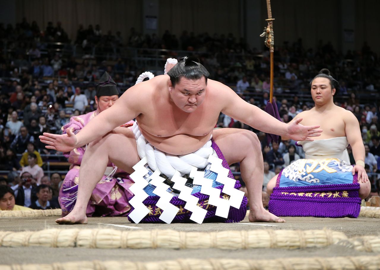 Hakuhō performs a ring-entering ceremony at the Kyūshū tournament on November 18, 2019. In choosing the less common Shiranui style, characterized by both arms held wide as opposed to just one arm in the more popular Unryū style, he dispelled the myth that a yokozuna performing the form is destined to have short career. (© Jiji)