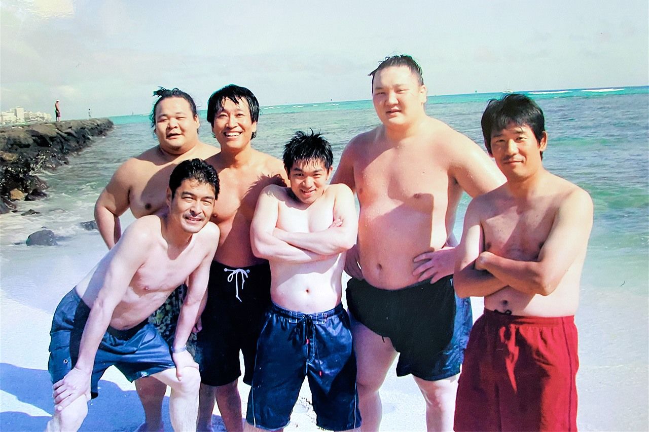 Hakuhō takes a break during a visit to the beach to pose with journalists covering the Hawaii Sumō tour in June 2006. The author is at the back between Hakuhō, right, and Ryūō. (Courtesy of the author)