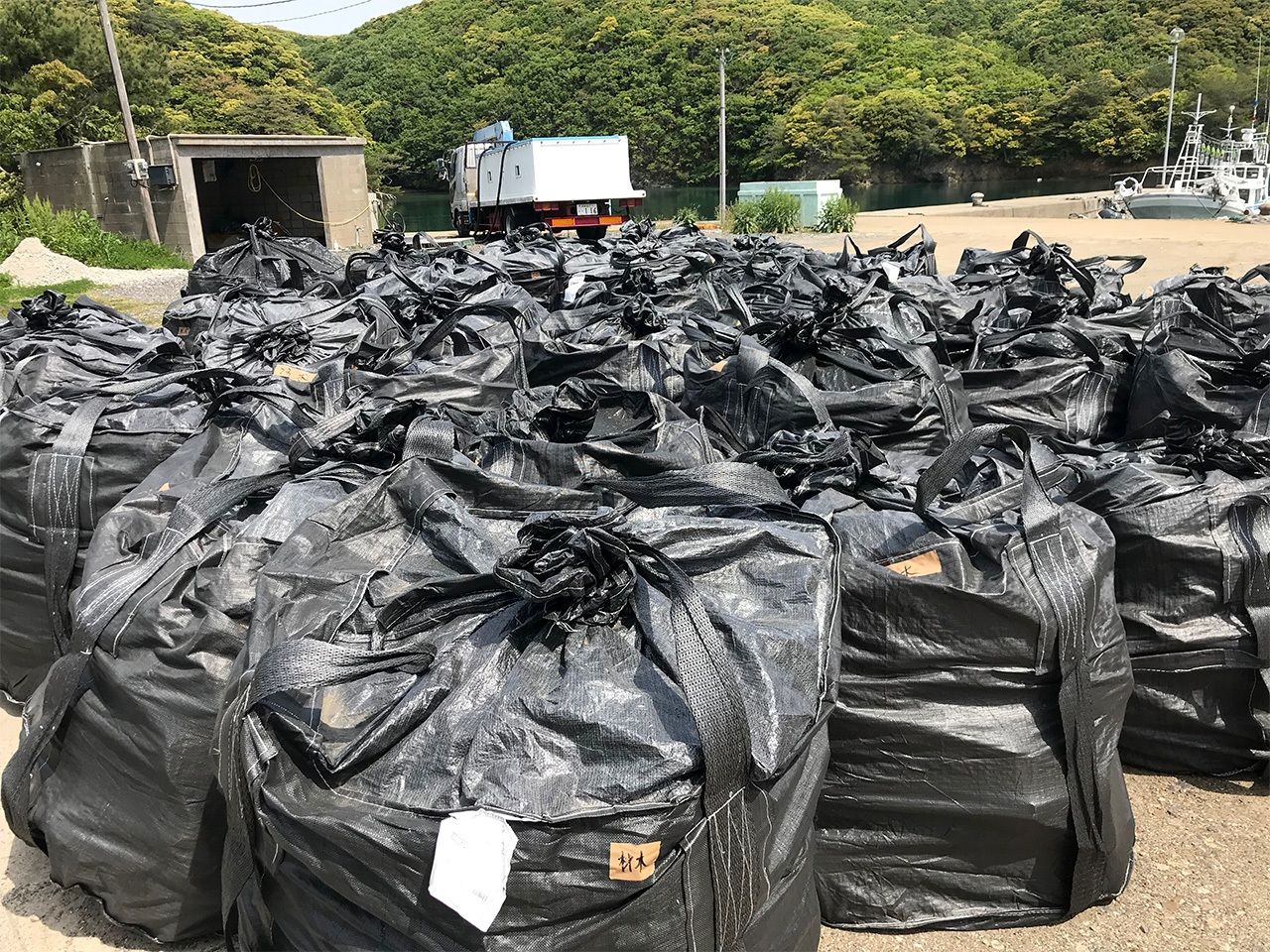 Bags stuffed with marine debris at a Tsushima port.