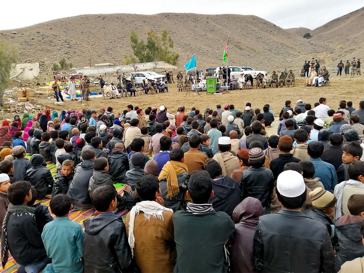 People gather for a ceremony to mark the reopening of the local school in March 2019. Army representatives can be seen to the right of the flagpole. (Photo courtesy Japanese Organization for International Cooperation in Family Planning)