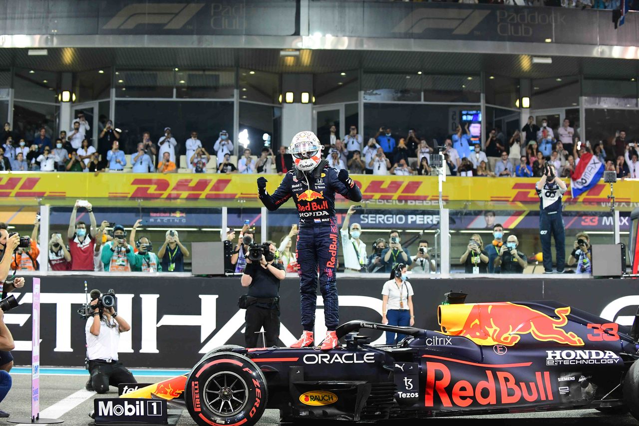 A jubilant Verstappen poses on his car after his final-lap victory over Hamilton on December 12, 2021, at the Abu Dhabi Grand Prix. (© Andrea Diodato; via Reuters Connect)