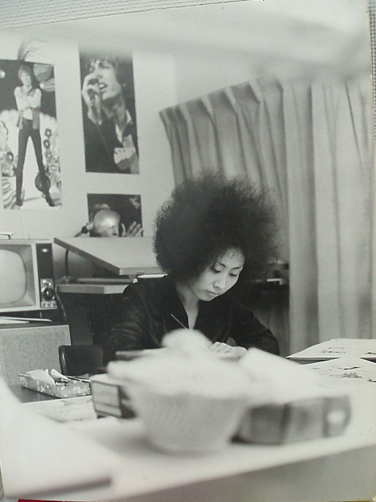 Mizuno at her desk, writing Faiyā! A poster of Scott Walker is on the wall behind her. (Courtesy of Mizuno Hideko)