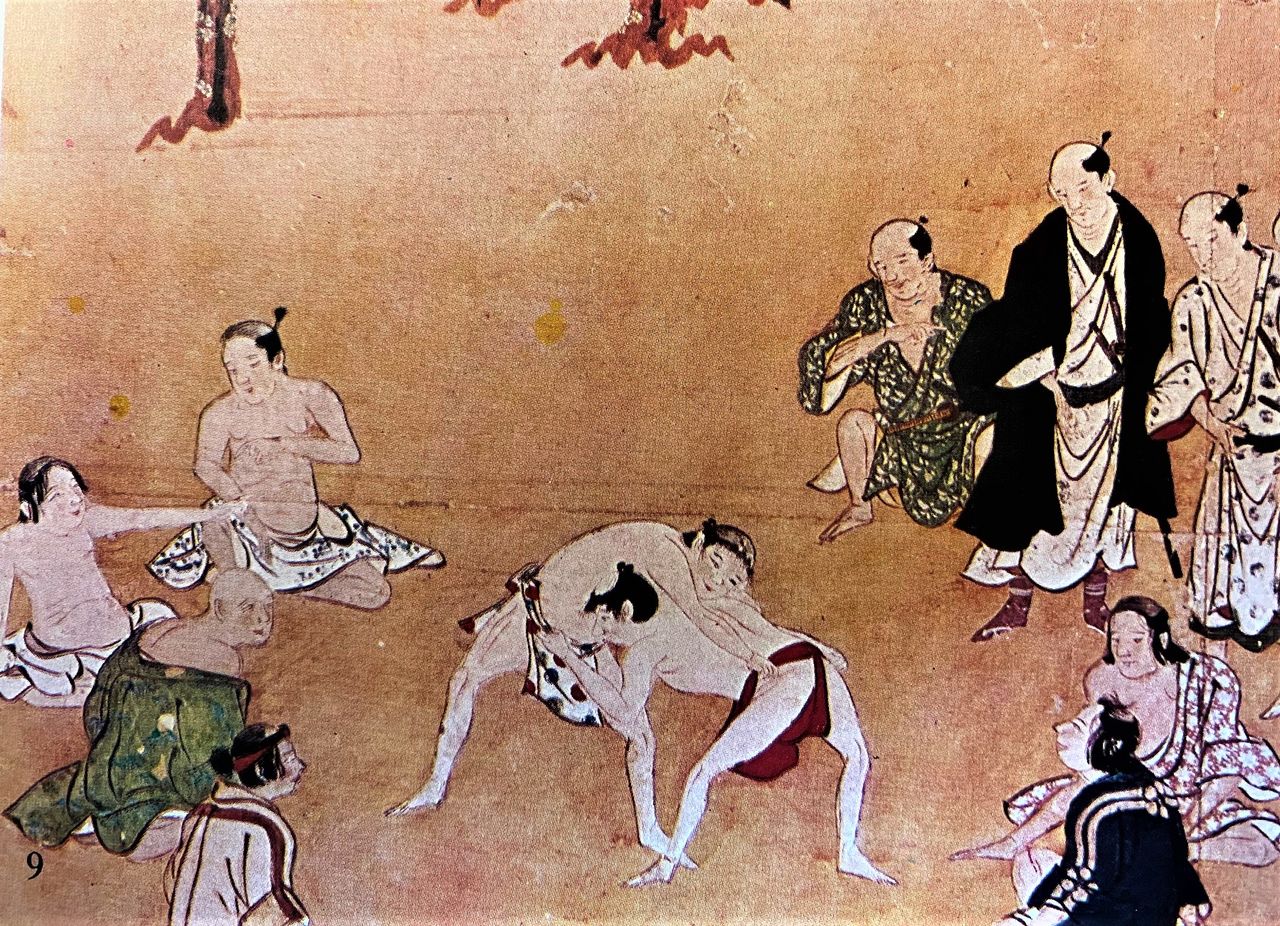 A Muromachi period (1336–1573) illustration depicting what is most likely a sumō match. The circle formed by the spectators around the men may mark the origin of the dohyō. (Courtesy Ōzumō Journal)