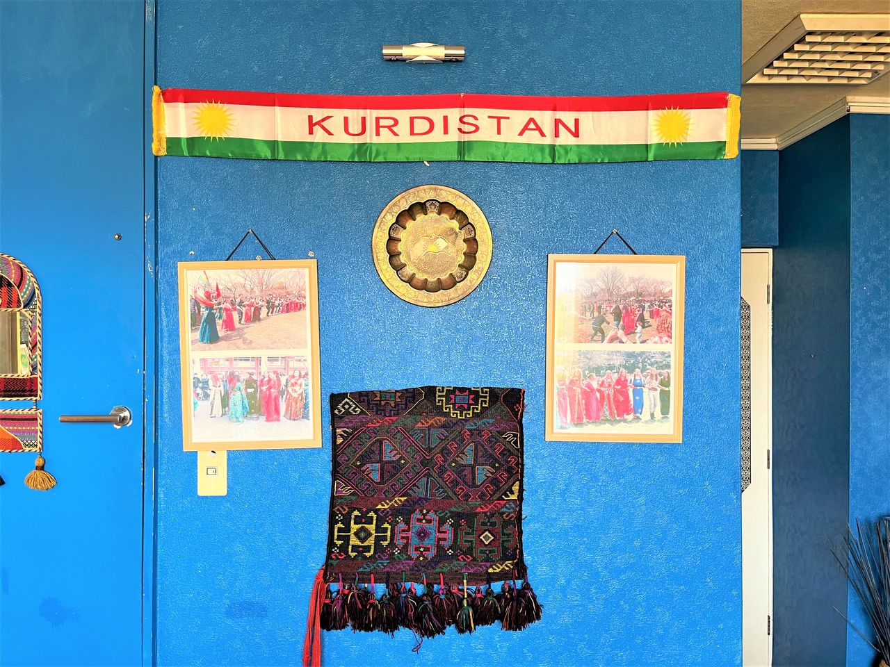 The restaurant also has Kurdish culture displays. The flag of red, green and white stripes overlaid with a sunburst is that of Kurdistan.