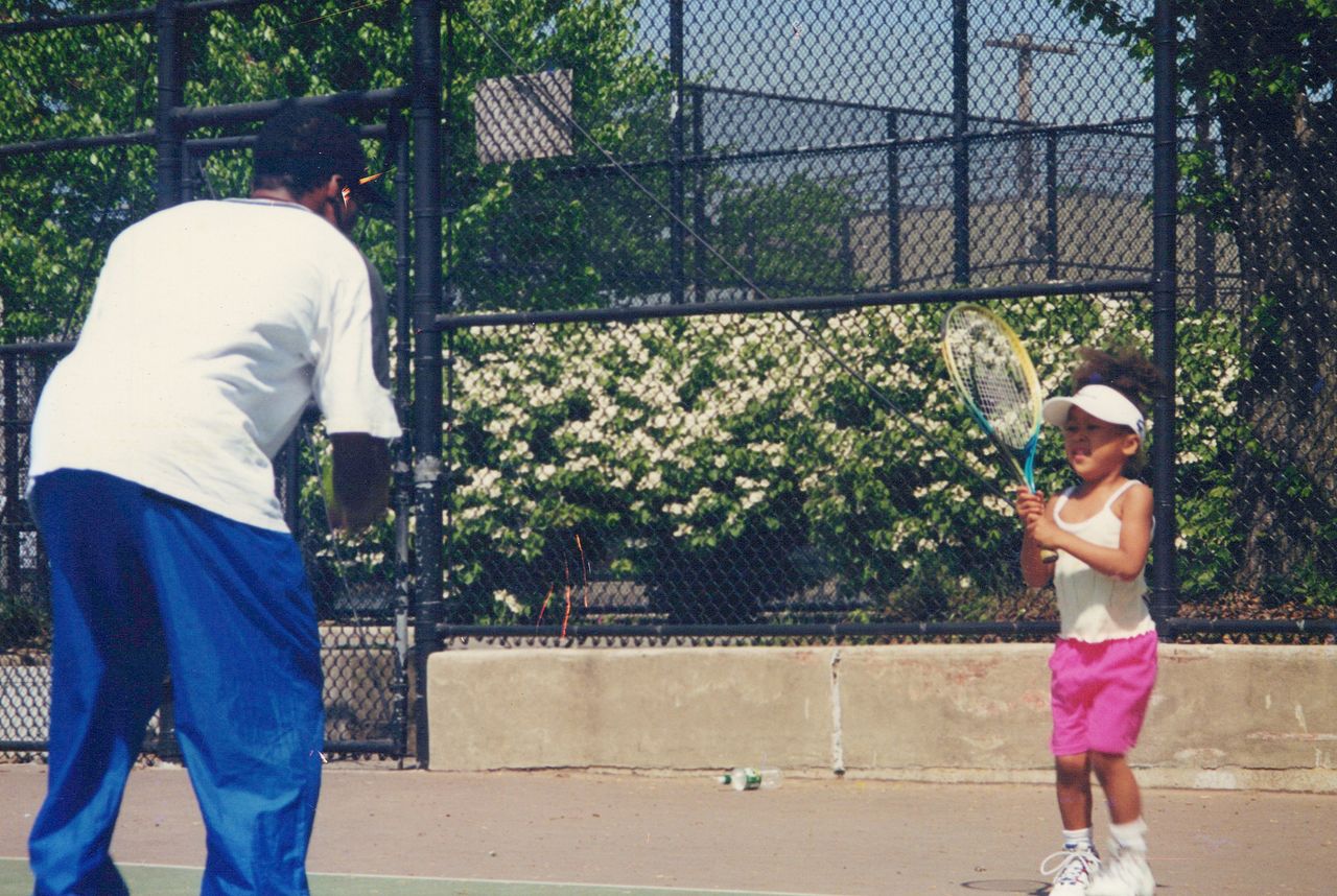 Three-year-old Naomi (right) practices with father Leonard at a public tennis court in New York shortly after the family moved to the city. (© Ōsaka Tamaki)