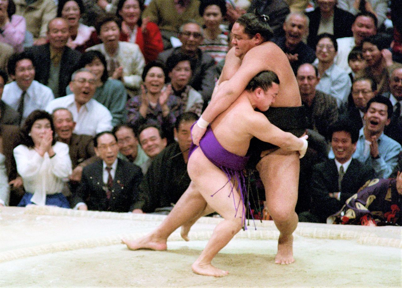 Mainoumi executes mitokoro-zeme against Akebono on November 20, 1991, at the Fukuoka Kokusai Center. (© Jiji)