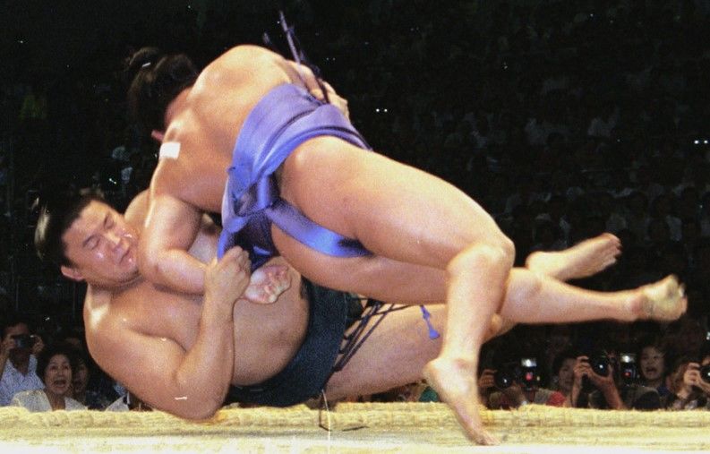 Mainoumi racked up his first win against Takanohana, forcing him down using kirikaeshi while falling himself, on July 4, 1994, at the Aichi Prefectural Gymnasium. (© Kyōdō)