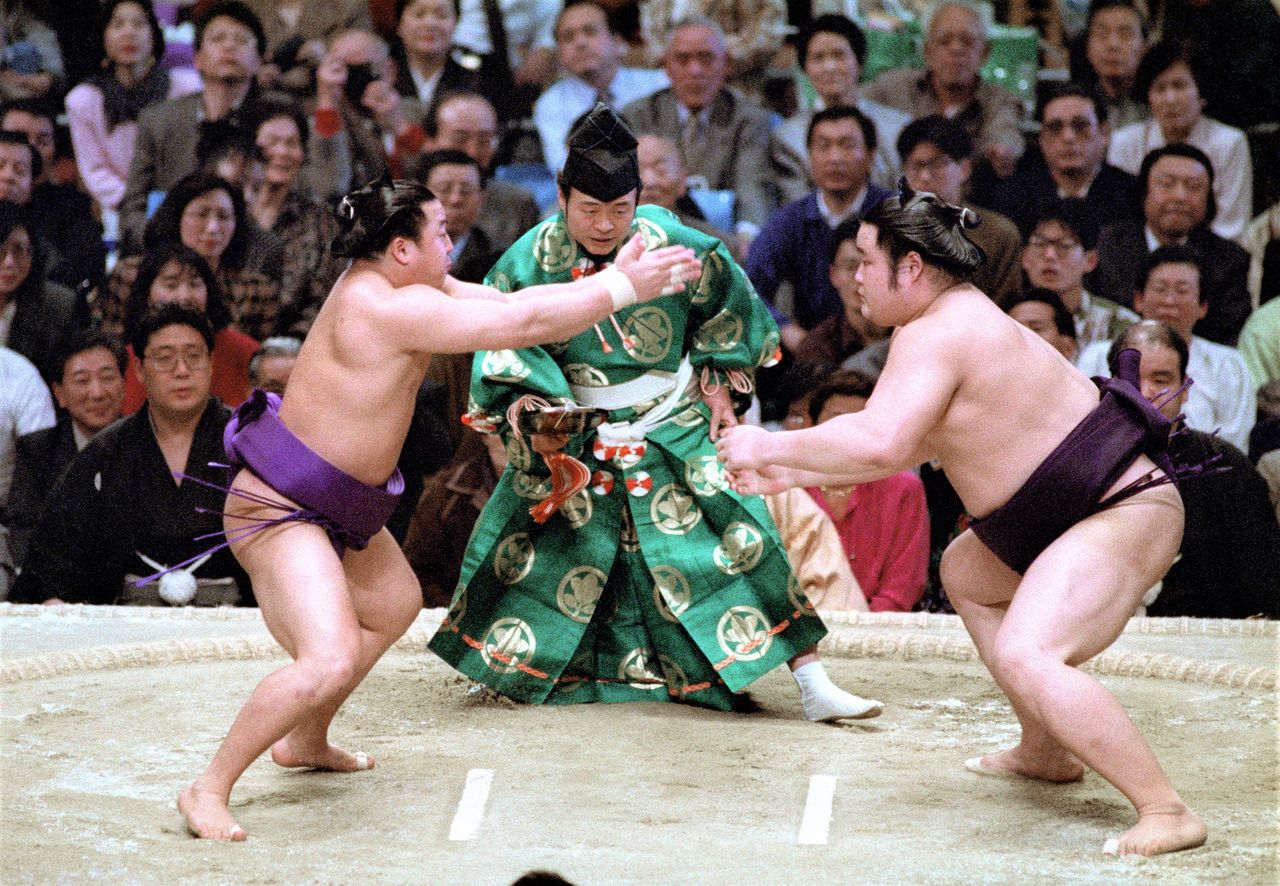 Mainoumi uses nekodamashi to throw Tomoefuji off his stride at the tachiai at the March 1992 basho. Taken on March 20, 1992, at the Osaka Prefectural Gymnasium. (© Jiji)