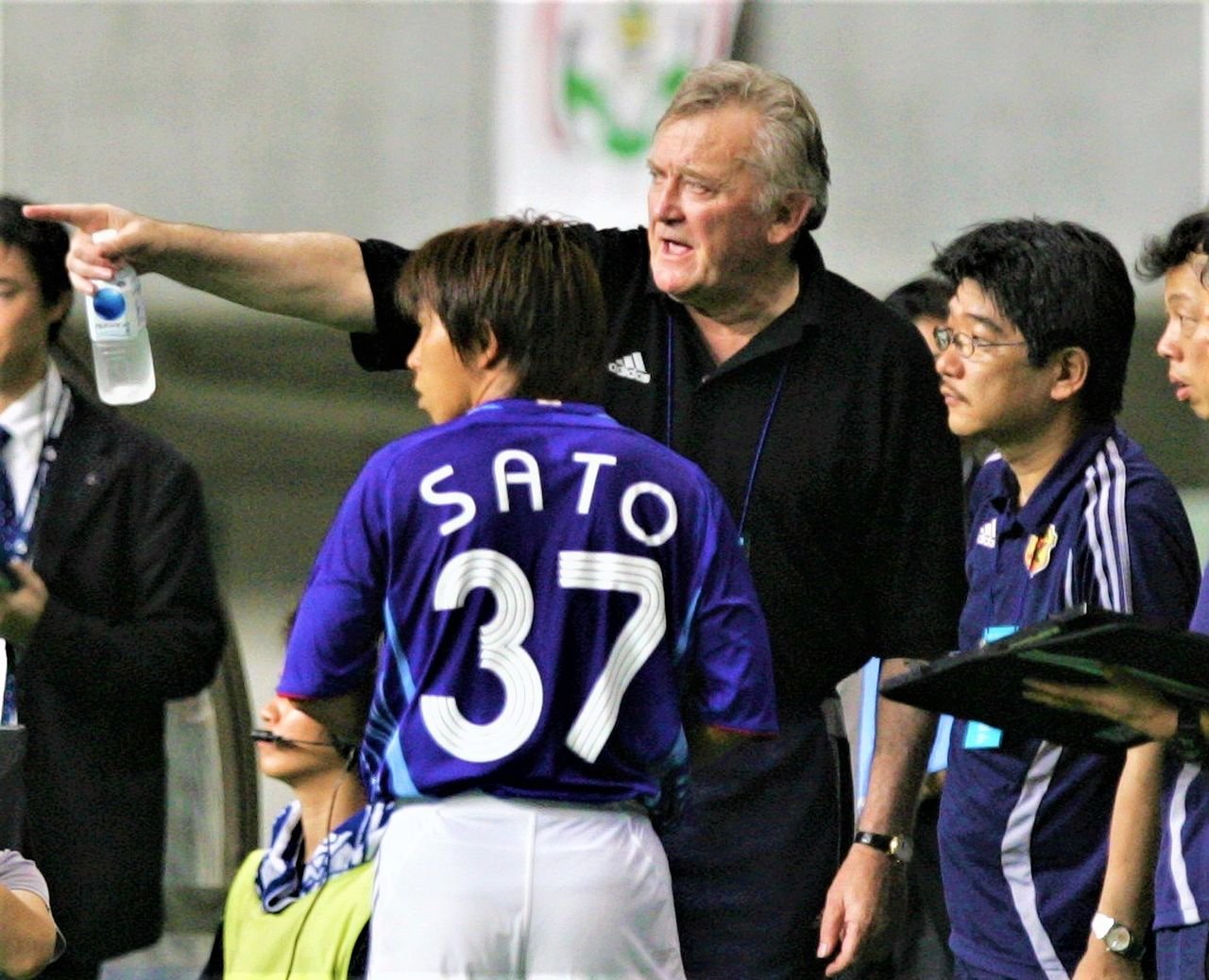 Japan national team manager Ivica Osim, center, gives instructions to forward Satō Hisato during a qualifying match of the Asian Cup at Niigata Stadium on August 16, 2006. (© Jiji)
