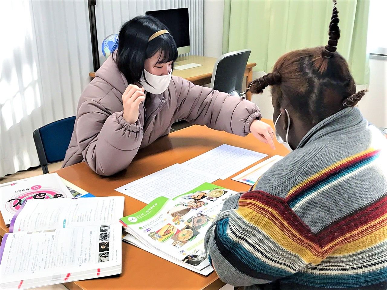 Oikawa on her first day at the refugee center teaches Japanese to a resident from Africa. She was introduced to the shelter by NGO head Urushibara Hiroshi, who helped guide the facility through the difficult funding application process.