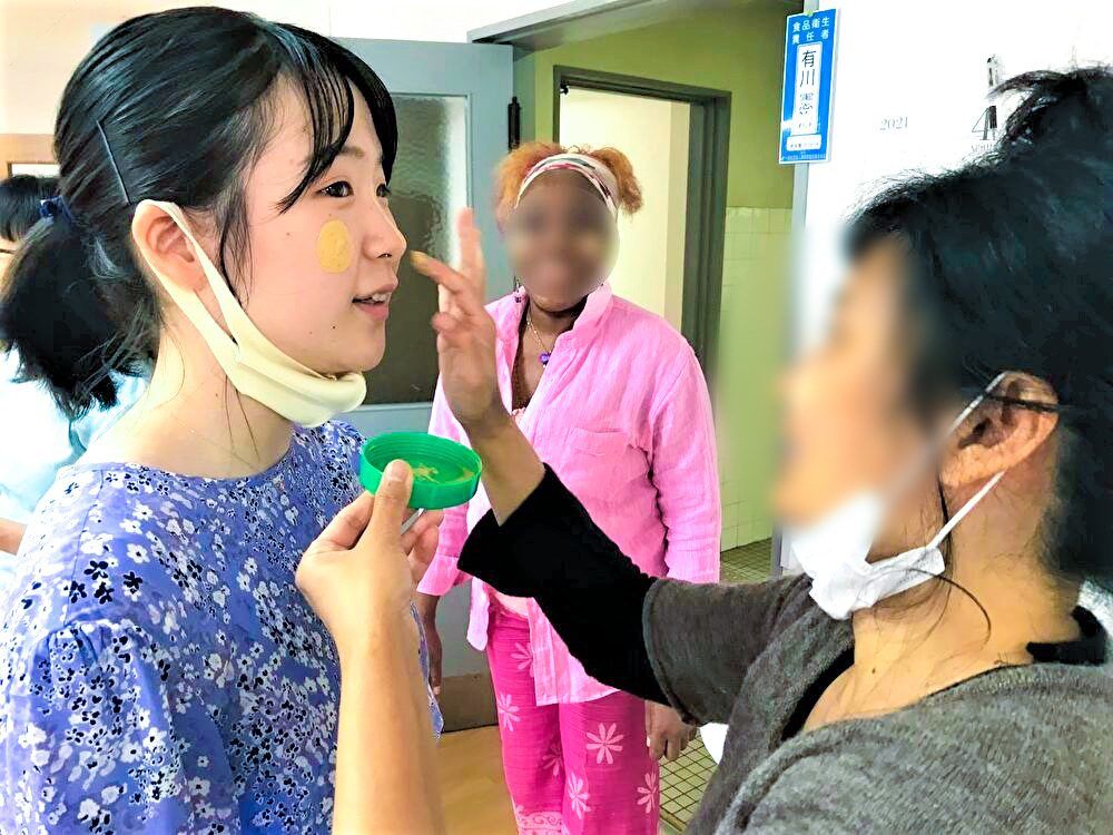A resident applies thanaka, a type of skin lotion used in Myanmar, to Oikawa’s face.