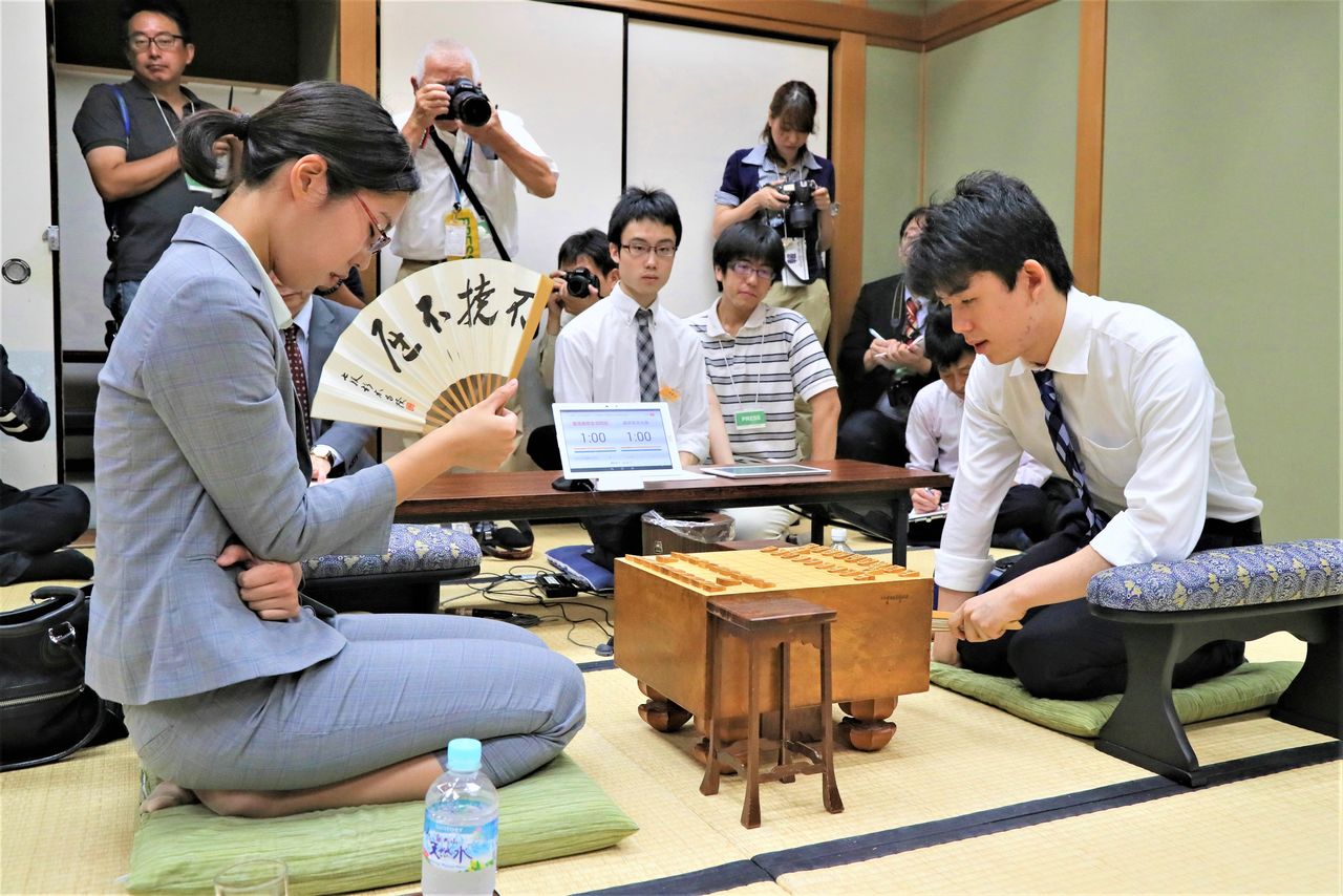 Satomi, left, faces off against teenage prodigy Fujii Sōta during the preliminary round of the Hulic Cup Kisei Tournament at the Kansai Shōgi Kaikan in Osaka on August 24, 2018. The match, which Fujii won, drew broad media attention. (© Jiji)